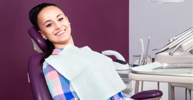 young women sitting in dental chair smiling
